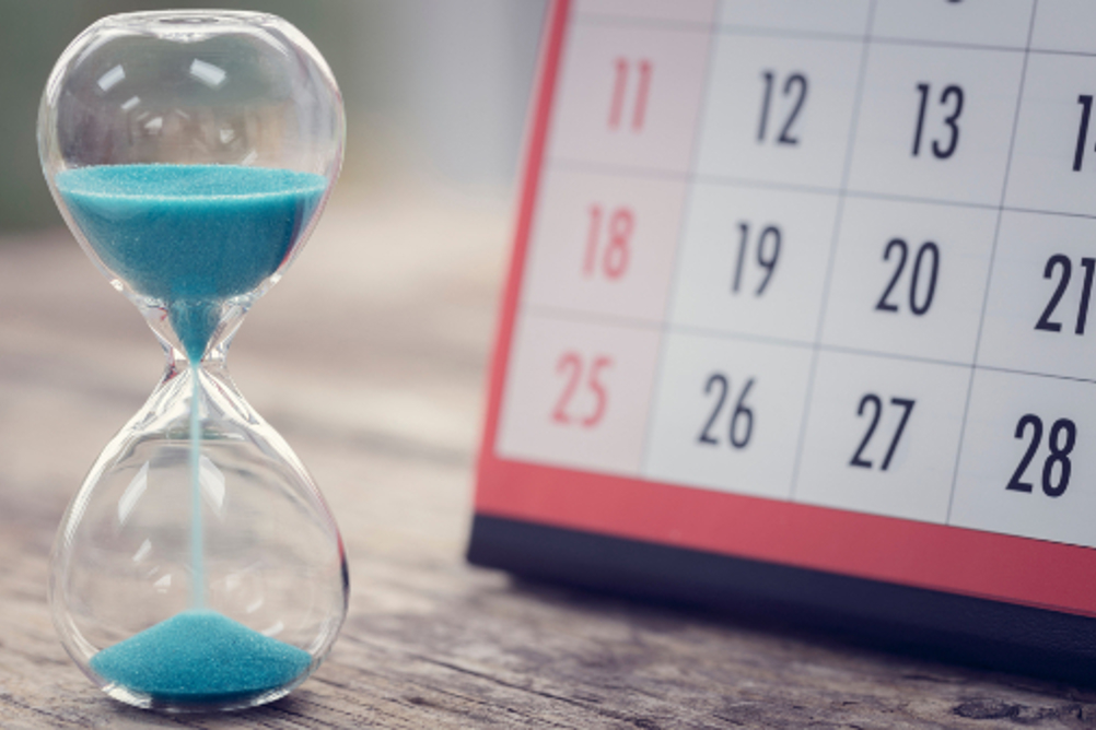 A Sandtimer Next To A Calendar To Illustrate The Passage Of Time