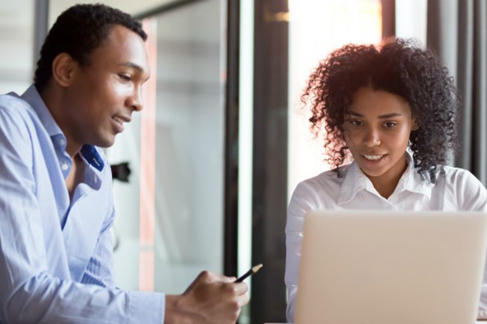 A male work and his female manager looking at a computer
