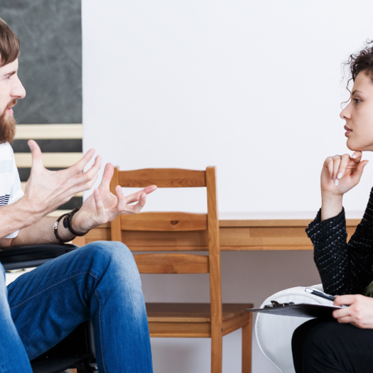 An occupational therapist talking to a man in a wheelchair as part of a needs assessment