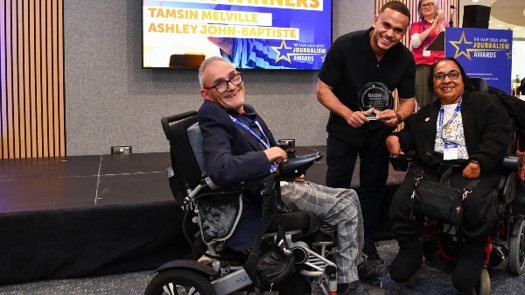 Ashley John-Baptiste (centre) receiving his journalism award from BASW Council members Mark Lynes and Reshma Patel, applauded by BASW chief executive Ruth Allen
(Credit: Simon Hadley)