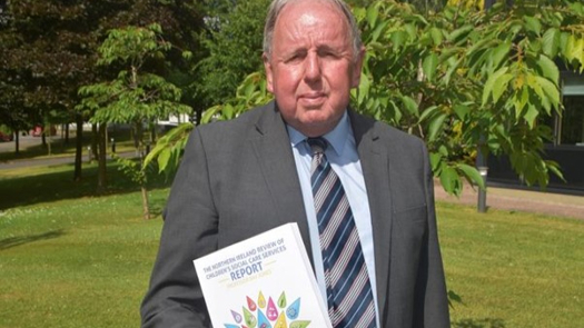 Ray Jones holding a copy of his report on children's social care in Northern Ireland
