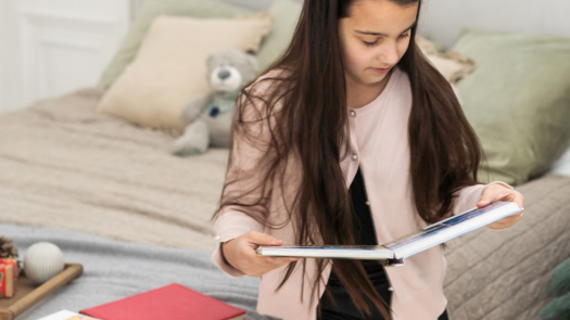 Photo: Angelov/Adobe Stock|A teenage girl looks at a photo book at Christmas.