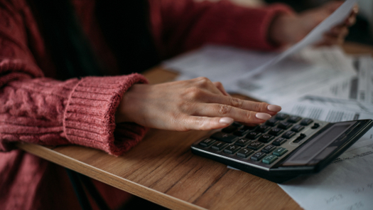 A woman using a calculator to calculate her pay